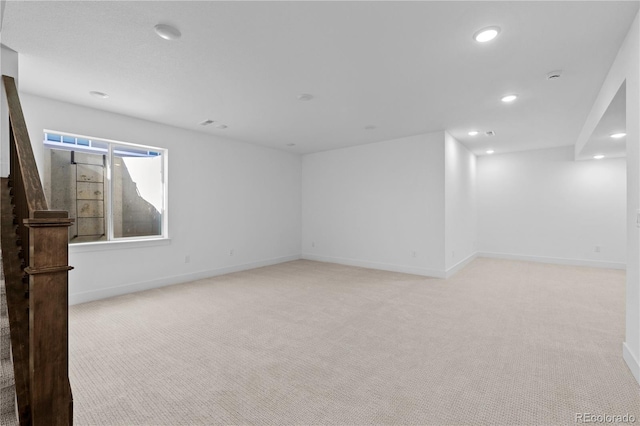 spare room with recessed lighting, light carpet, and baseboards