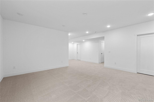 unfurnished room featuring recessed lighting, light carpet, and baseboards