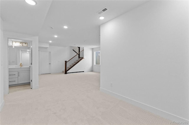 below grade area featuring recessed lighting, visible vents, stairway, light carpet, and baseboards