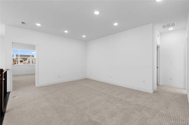 spare room featuring recessed lighting, visible vents, and light colored carpet