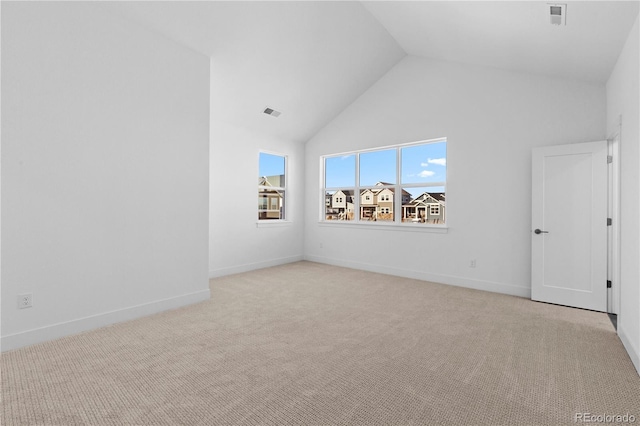 empty room with light carpet, high vaulted ceiling, visible vents, and baseboards