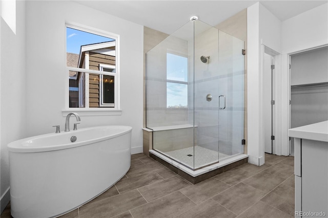 full bathroom featuring a stall shower, baseboards, and a freestanding bath