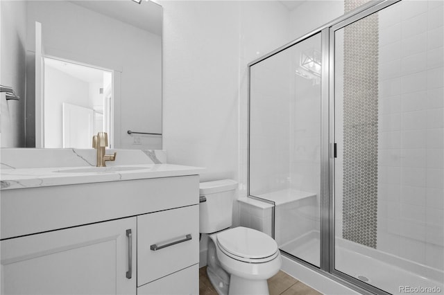 full bathroom with a stall shower, tile patterned flooring, vanity, and toilet