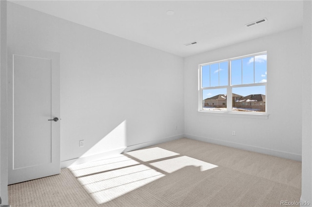 spare room with carpet, visible vents, and baseboards