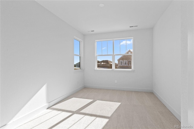 carpeted empty room featuring visible vents and baseboards