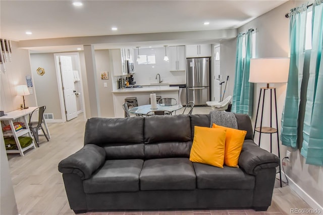 living room with sink and light hardwood / wood-style floors