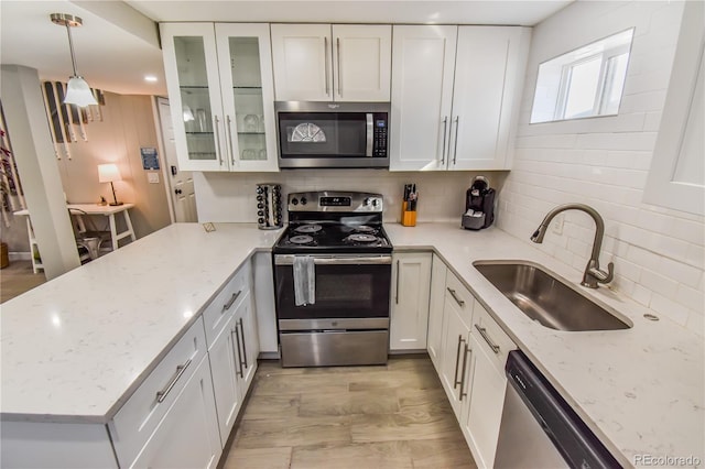 2200 W Moffat Pl, Denver, CO 80221 - kitchen featuring stainless steel appliances, a sink, backsplash, and white cabinetry