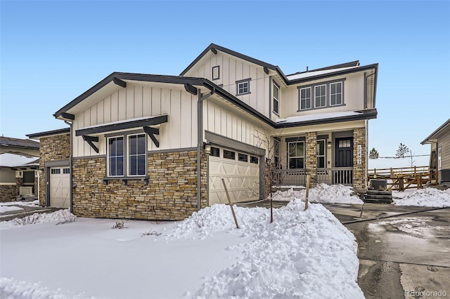 view of front of house featuring board and batten siding, stone siding, covered porch, and a garage