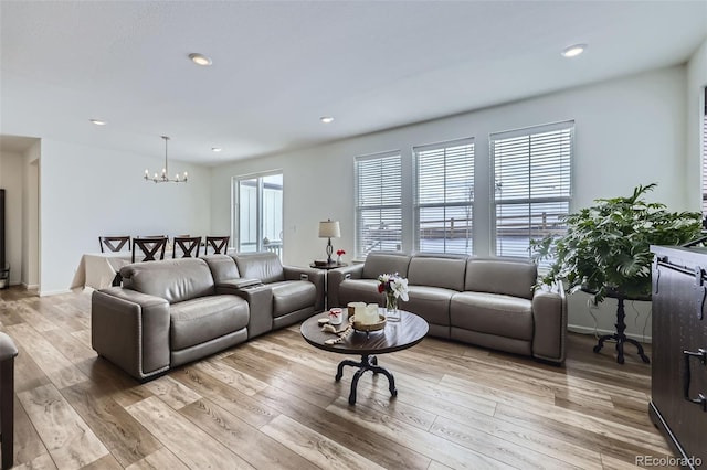 living room featuring a chandelier, baseboards, light wood-style flooring, and recessed lighting