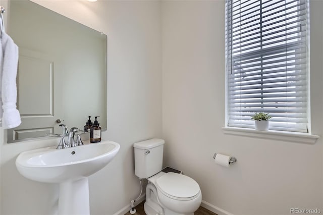 bathroom with toilet and baseboards