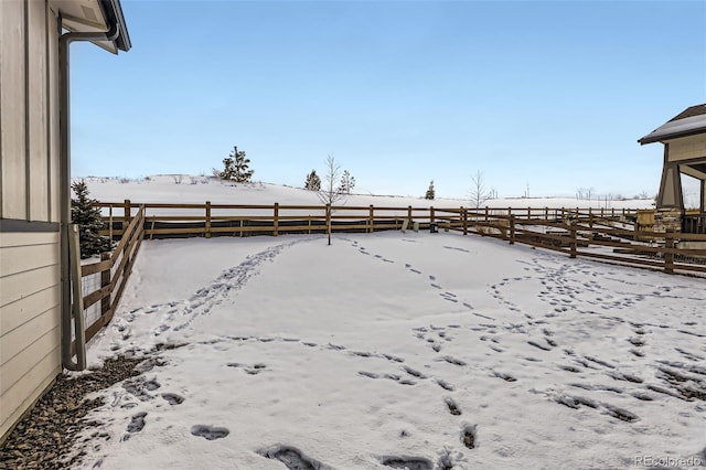 yard layered in snow featuring fence