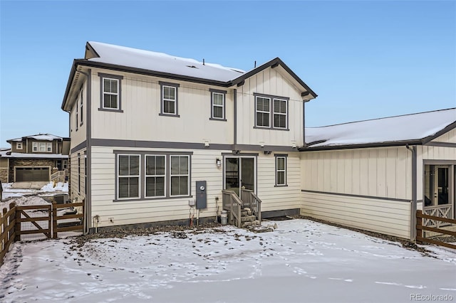 snow covered property featuring entry steps and fence