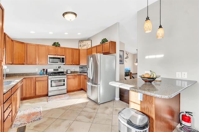 kitchen featuring light stone counters, a breakfast bar area, hanging light fixtures, appliances with stainless steel finishes, and a peninsula