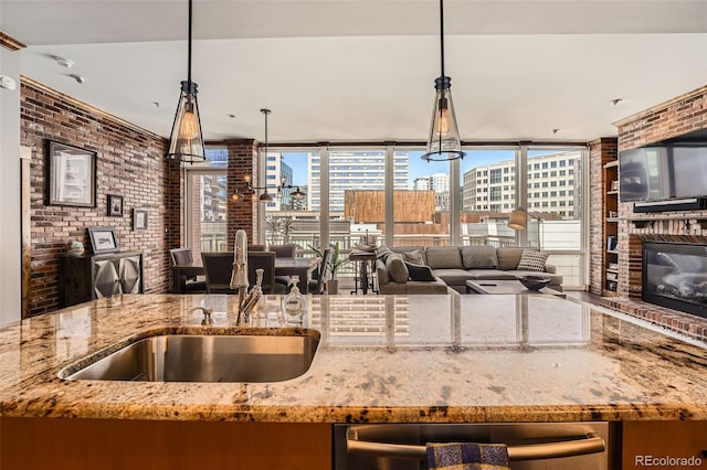 1401 Delgany St Unit 409, Denver, CO 80202 - kitchen with a sink, brick wall, pendant lighting, light stone counters, and floor to ceiling windows