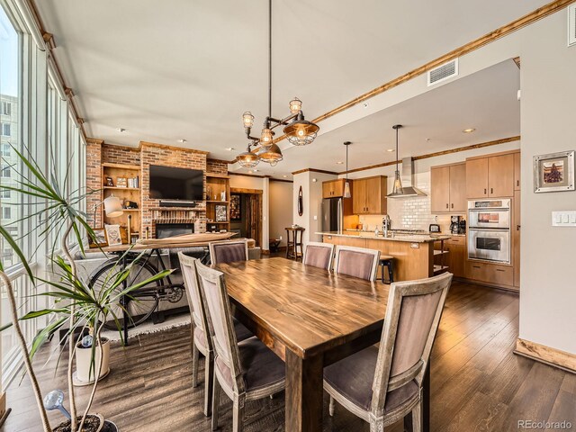 1401 Delgany St Unit 409, Denver, CO 80202 - dining area with dark wood-style floors, a fireplace, recessed lighting, a chandelier, and baseboards