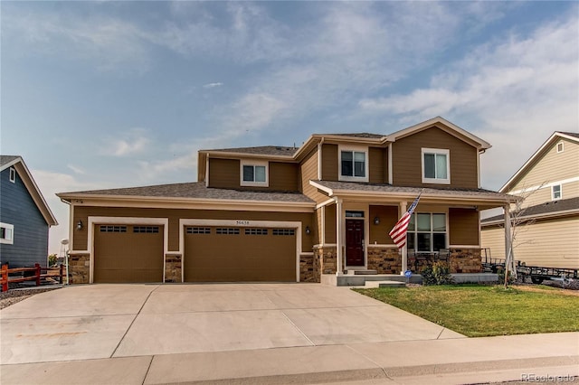 view of front of house with a garage, a front lawn, and covered porch