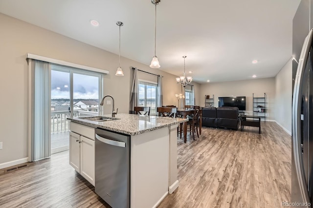 5256 Trails Edge Ln, Castle Rock, CO 80104 - kitchen featuring appliances with stainless steel finishes, a sink, white cabinetry, open floor plan, and light wood-type flooring