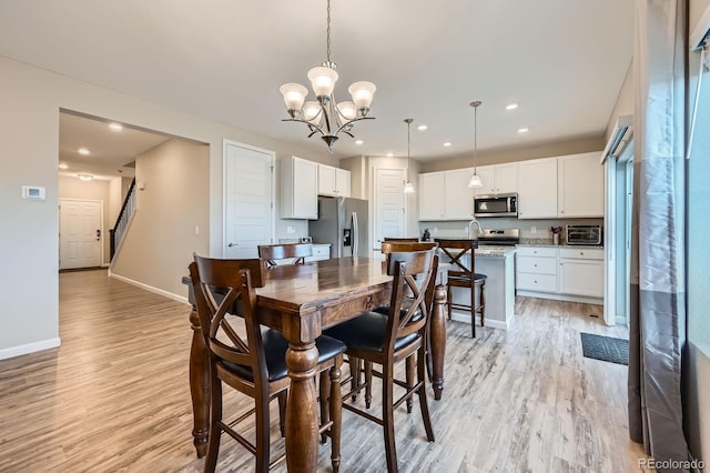5256 Trails Edge Ln, Castle Rock, CO 80104 - dining space featuring a toaster, baseboards, stairway, light wood finished floors, and a notable chandelier