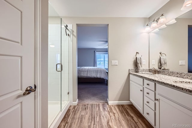 5256 Trails Edge Ln, Castle Rock, CO 80104 - bathroom featuring double vanity, a shower stall, wood finished floors, a sink, and ensuite bathroom