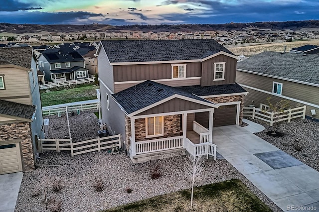 5256 Trails Edge Ln, Castle Rock, CO 80104 - view of front of home with fence, stone siding, board and batten siding, concrete driveway, and covered porch