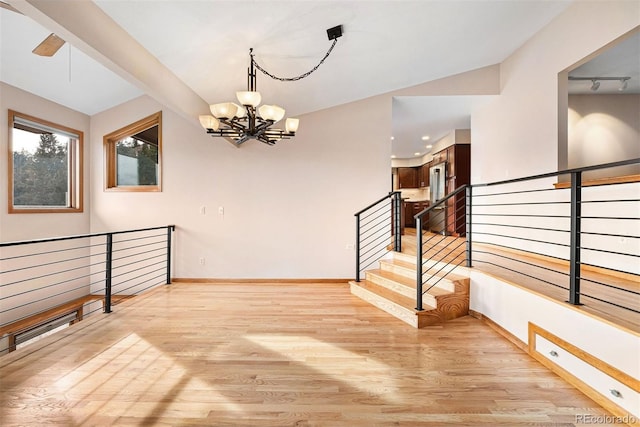 interior space with light hardwood / wood-style flooring and ceiling fan with notable chandelier