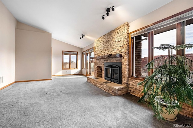 unfurnished living room featuring carpet flooring, a fireplace, track lighting, and vaulted ceiling