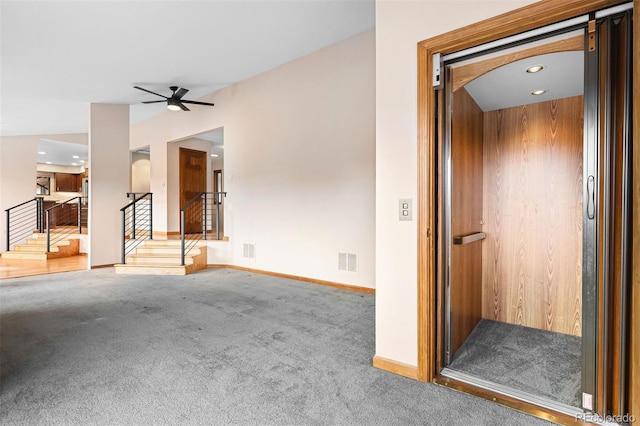 unfurnished living room featuring carpet flooring, elevator, and ceiling fan