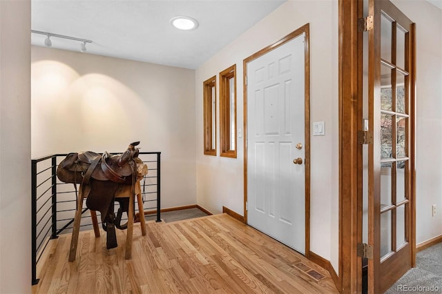 foyer entrance with track lighting and light wood-type flooring