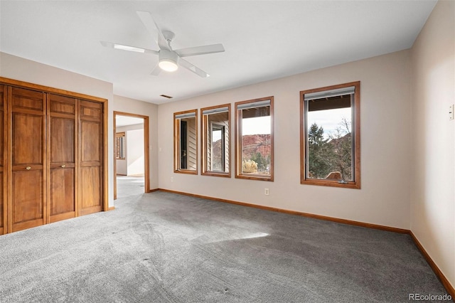 unfurnished bedroom with carpet, ceiling fan, and a closet