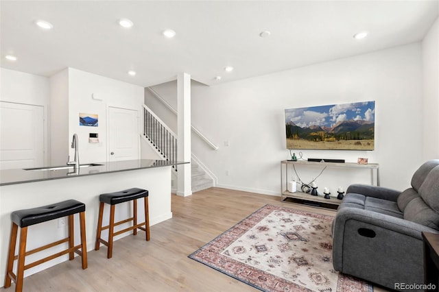 living room with light hardwood / wood-style floors and sink