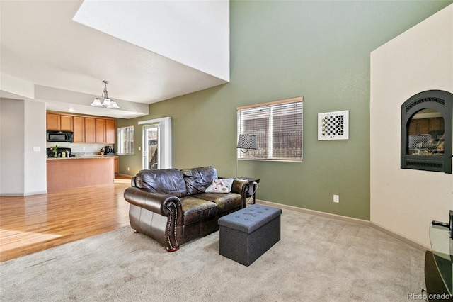 living room featuring a notable chandelier and light wood-type flooring