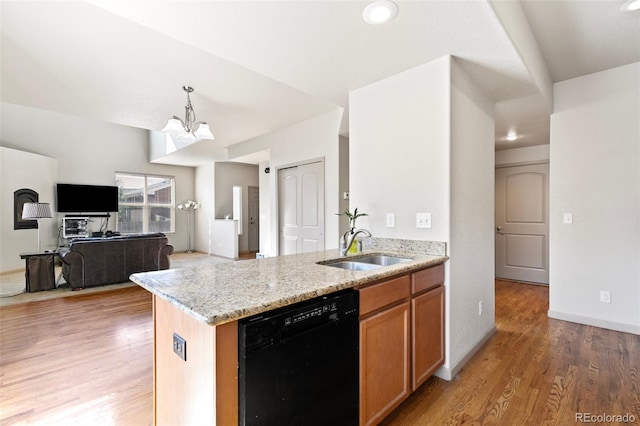 kitchen featuring dishwasher, light hardwood / wood-style flooring, sink, an inviting chandelier, and light stone counters