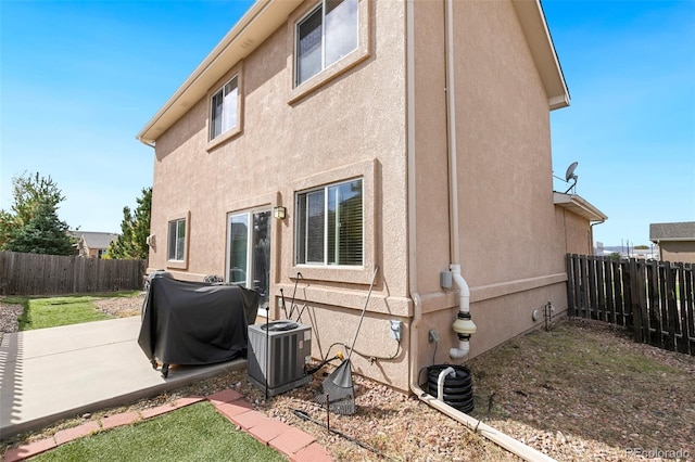 view of property exterior featuring cooling unit and a patio area