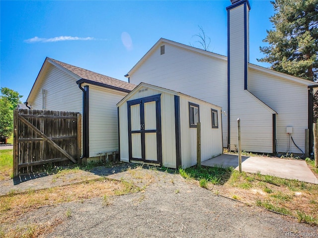 655 Gooseberry Ct, Lafayette, CO 80026 - view of property exterior with a chimney, a storage shed, and a patio