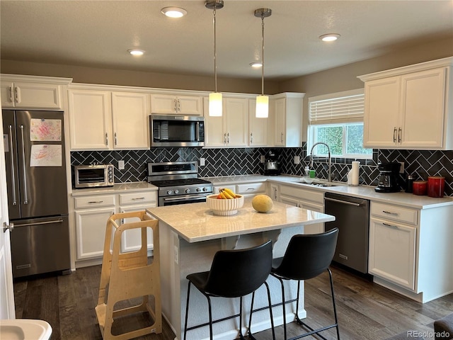 12901 Crane River Dr, Longmont, CO 80504 - kitchen with dark wood-style flooring, a sink, white cabinets, and stainless steel appliances