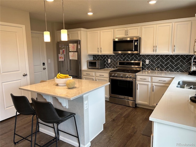 12901 Crane River Dr, Longmont, CO 80504 - kitchen featuring dark wood finished floors, light countertops, white cabinetry, and stainless steel appliances