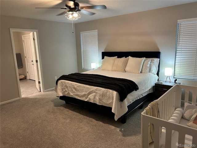 12901 Crane River Dr, Longmont, CO 80504 - bedroom with light carpet, ensuite bathroom, baseboards, and a ceiling fan