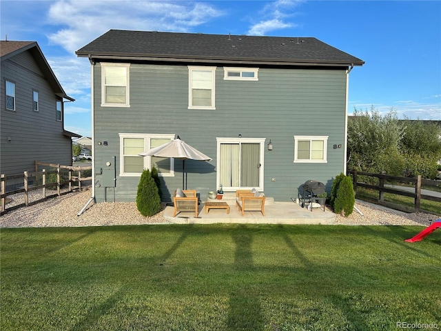 12901 Crane River Dr, Longmont, CO 80504 - back of property with roof with shingles, a patio area, a fenced backyard, and a lawn
