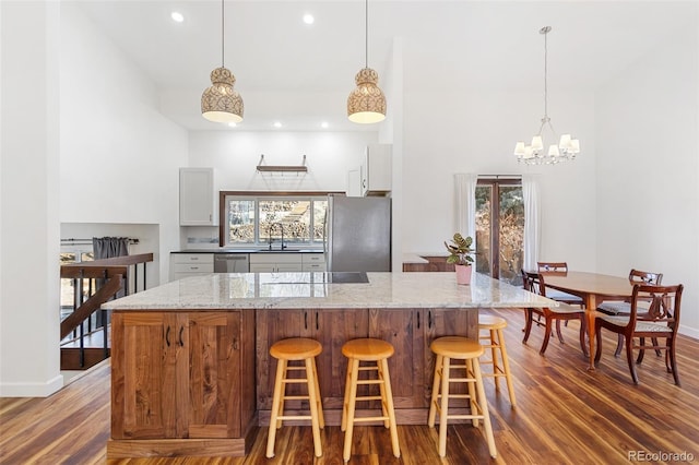 kitchen with white cabinetry, light stone countertops, dark hardwood / wood-style floors, and appliances with stainless steel finishes