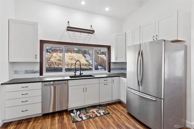 kitchen featuring white cabinets, stainless steel appliances, dark wood-type flooring, and sink