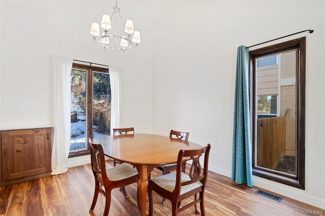 dining space with a notable chandelier and hardwood / wood-style flooring