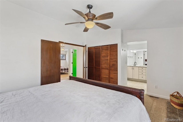 carpeted bedroom featuring connected bathroom, ceiling fan, a closet, and vaulted ceiling