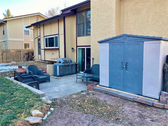 back of house featuring a patio area, an outdoor living space, and a storage shed