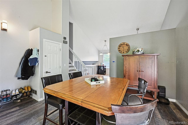 dining room with high vaulted ceiling and dark hardwood / wood-style floors