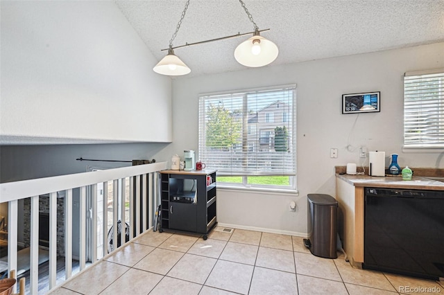 laundry room with plenty of natural light, light tile patterned floors, and a textured ceiling