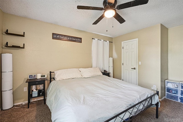 bedroom with ceiling fan, dark carpet, and a textured ceiling