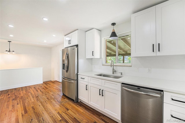2280 Sherrelwood Dr, Denver, CO 80221 - kitchen with stainless steel appliances, a sink, decorative backsplash, hanging light fixtures, and recessed lighting