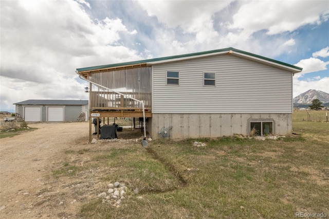 15980 County Road 306, Buena Vista, CO 81211 - rear view of house featuring a garage, a deck with mountain view, and driveway