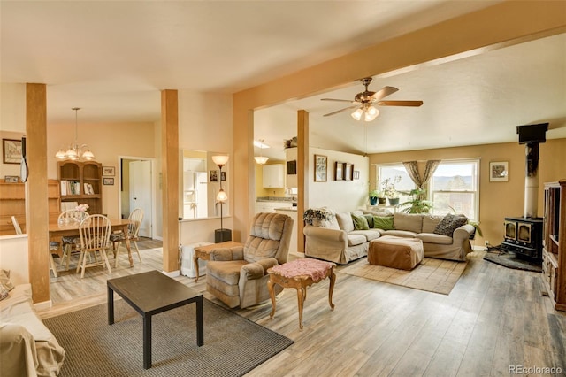 15980 County Road 306, Buena Vista, CO 81211 - living room with lofted ceiling with beams, wood finished floors, a wood stove, and ceiling fan with notable chandelier