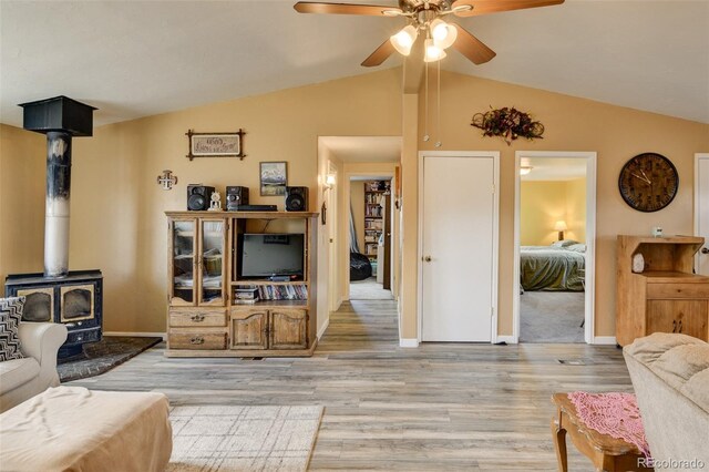 15980 County Road 306, Buena Vista, CO 81211 - living room with light wood finished floors, a wood stove, a ceiling fan, baseboards, and vaulted ceiling